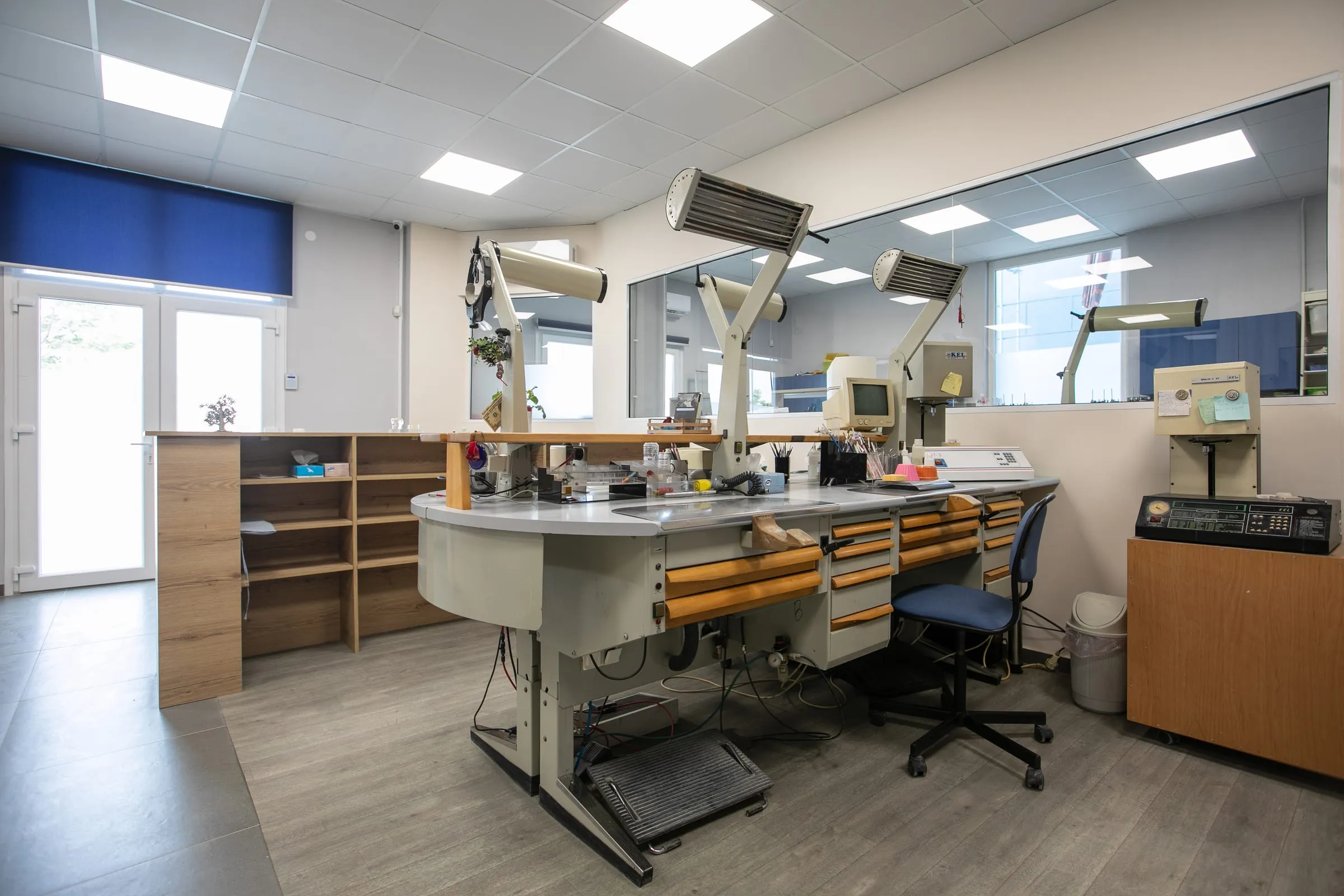 Technician benches with task lamps and microscopes at the EstheTeeth lab
